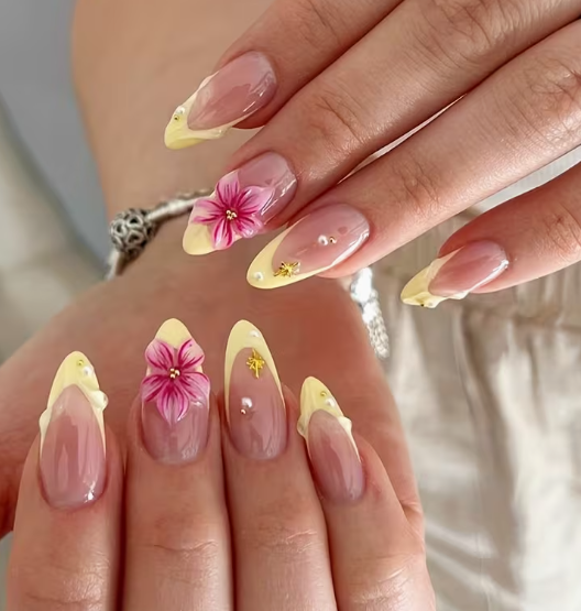 Unghie press on mandorla french con fiore rosa e charm dorato indossate